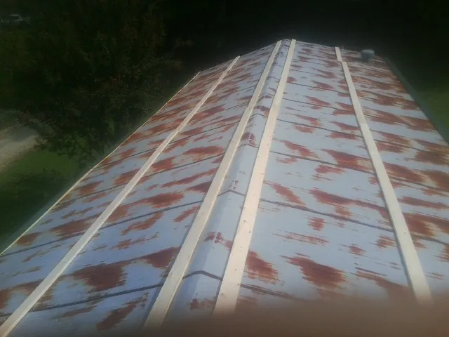 Rusted metal roof panels with new wood purlins before replacement — Storm Damage Roof Repair in Big Run by Roofing Brothers