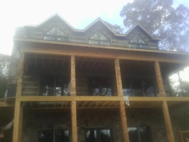 Dormers and porch framing on a large log home under construction — Roof Coating work by our crew in Big Run
