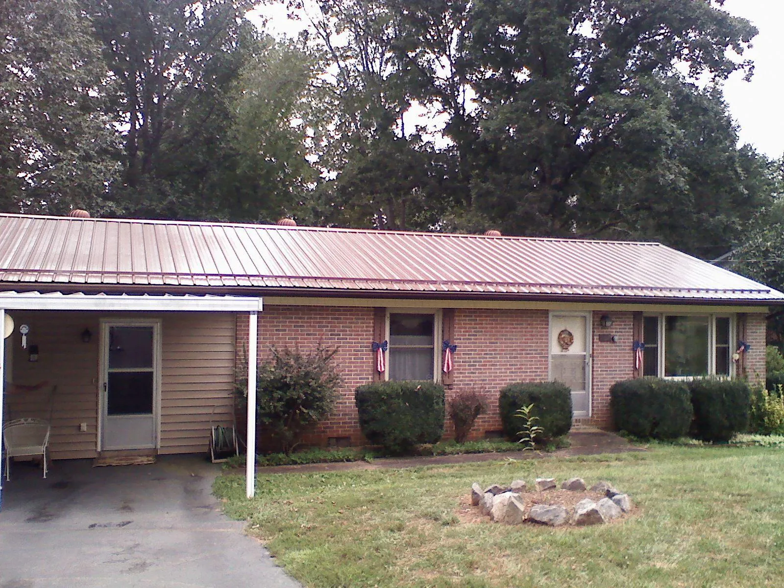 Bronze metal roof and carport on a brick ranch home — Roof Repair work by our crew in Big Run