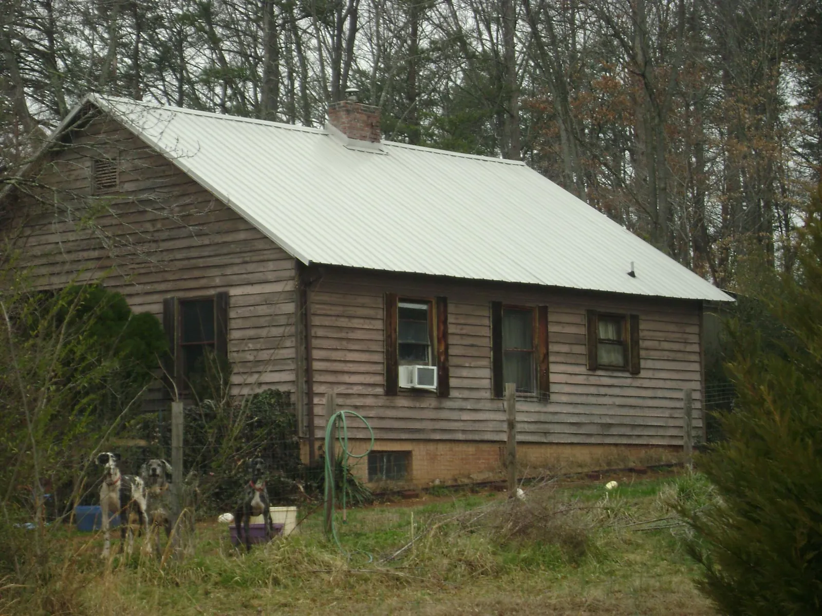 White metal roof on an old wood sided farmhouse, from a Metal Roof Installation job in Big Run